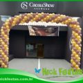 Decoração com arco de balões personalizado nas cores da marca para evento empresarial