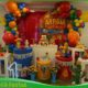 Decoração infantil Festa Junina montada em salão de festas com painel temático, bandeirinhas coloridas, balões, fogueira cenográfica, cactos decorativos, mesa personalizada e elementos caipiras para aniversário infantil na Freguesia do Ó, São Paulo.