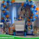 Decoração de festa infantil com tema Bluey, incluindo painel colorido, mesas decoradas e personagens da série.