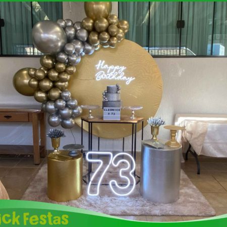 Decoração dourado e prata para festa de 70 anos, com painel decorativo, arco de balões, mesa principal e elementos sofisticados para comemoração de aniversário.